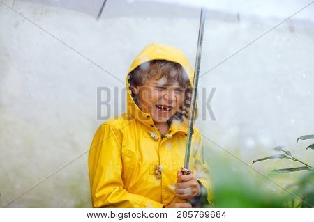 Beautiful Little Kid Boy On Way To School Walking During Sleet, Heavy Rain And Snow With An Umbrella