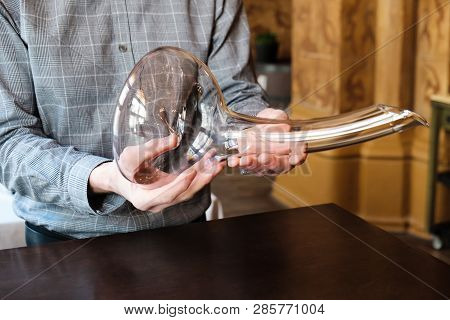 Man Sommelier Presenting An Empty Elegant Phallic Glass Decanter