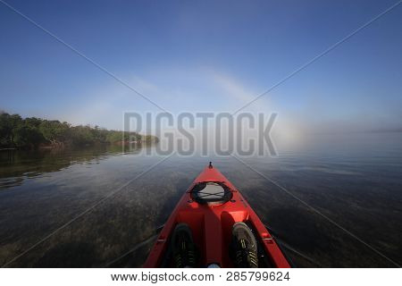 Key Biscayne, Florida 01-16-2016 Red Kayak Heading Toward A Bright Fogbow Over Bear Cut Off Key Bisc