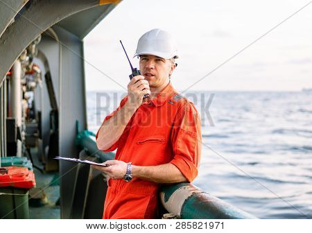 Deck Officer On Deck Of Offshore Vessel Holds Vhf Walkie-talkie Radio