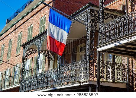 Balcony Of A French Quarter House In New Orleans, Louisiana, With A French Flag Hanging From Balcony