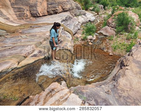 Young Woman Enjoys Some Downtime In Hermit Creek During A Multi-day Backpacking Expedition On The He
