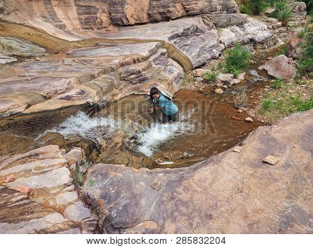 Young Woman Enjoys Some Downtime In Hermit Creek During A Multi-day Backpacking Expedition On The He