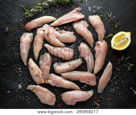 Raw Chicken Breast Mini Fillets In Rastic Cast Iron Skillet, Frying Pan With Herbs And Sea Salt