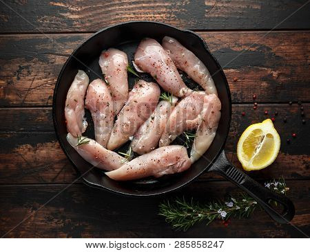 Raw Chicken Breast Mini Fillets In Rastic Cast Iron Skillet, Frying Pan With Herbs And Sea Salt