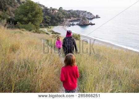 Family walking on the Andalusian beach in winter, Cala del CaÃ±uelo, Spain