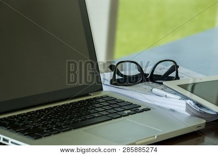 Work Area With Work Devices, Including Laptops, Tablets, Work Documents, Notebooks, Pens And Glasses