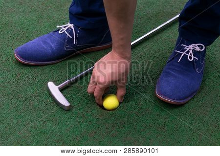 Minigolf Player Pulls A Yellow Ball From The Hole View From Above, Close-up