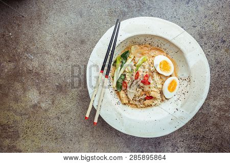 Japanese Ramen Noodle With Chicken, Shiitake Mushroms And Egg In White Bowl, Top View