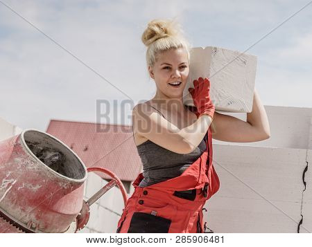 Strong Pretty Woman Working On Construction Site, Building House, Installing Gray Airbricks. Industr