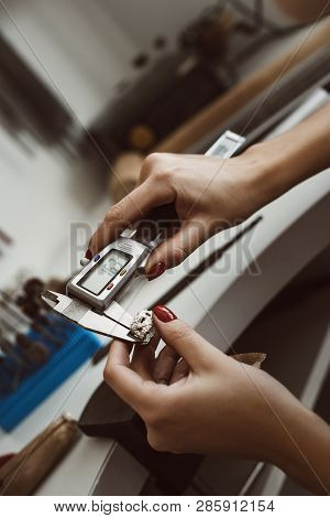 Do It Right. Close Up Photo Of Female Jewelers Hands Measuring Ring With A Tool In Workshop.