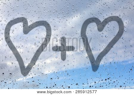 Picture Of Two Hearts On A Misted Glass. Glass Window With Raindrops Against The Blue Sky. Concept O
