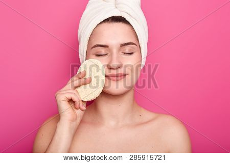 European Young Woman Enjoys Softness Of Skin, Touches Cheeks With Sponge, Removes Makeup, Has Please