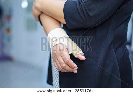 Asian Middle-aged Lady Woman Use Elastic Bandage To Treating De Quervain Syndrome At Hand And Finger