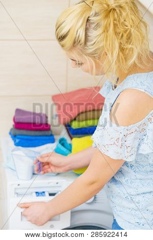 Washing Powder Detergent And Measuring Cup Pouring Into Machine. Household Duties, Clothes Laundry O
