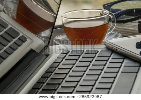 The Window Work Area Has A Laptop With A Notebook, Pen And River Views In The Near Term.