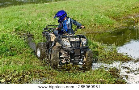 The Boy Is Traveling On An Atv.