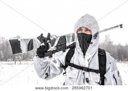 Man Soldier In The Winter On A Hunt With A Sniper Rifle In White Winter Camouflage Goes To The Field