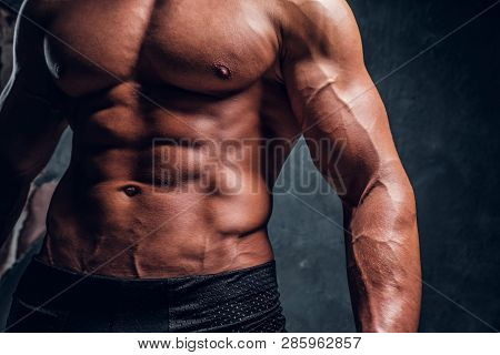 Naked Ahletic Man With Muscular Body. Close-up Image Of Torso With Dark Wall Background