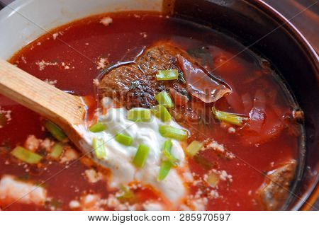 A Bowl Of Red Ukrainian Borshch (borsh) - A Beetroot Soup With Pork And Vegetables, Served With Sour