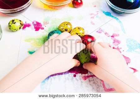 Child's Hands Moving Colorful Easter Quial Eggs On The Tissue