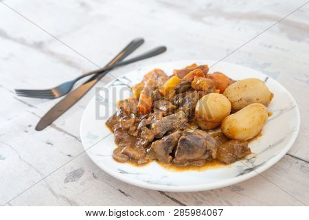 Beef meat stewed with potatoes-Traditional French cuisine Beef Bourguignon potatoes carrots in persillade
