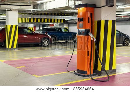 Electric Car Fast Charging Station At Indoor Underground Parking. Power Supply Point Network For Hyb
