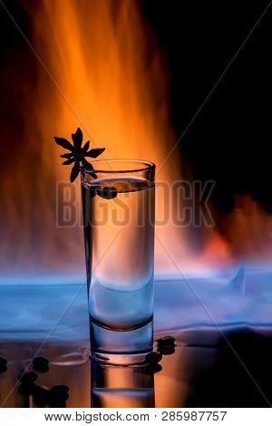One Glass Of Sambuca On Fire With Burning Sambuca, Coffee Grains And Anise Star On A Black Backgroun