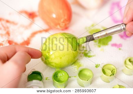 Close Up Of Kid  S Hand Holding An Ester Egg During Painting. Happy Ester Concept