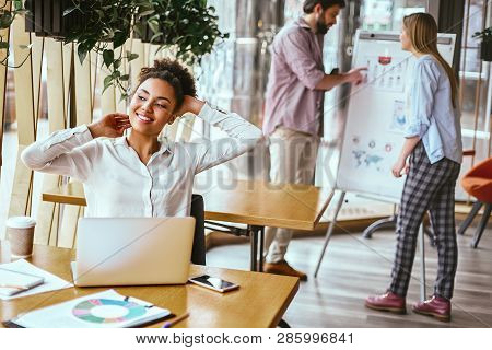 Be Undeniably Good. Happy Businesswoman Sitting At Her Desk And Leaning Back While Stretching