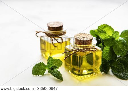 Organic Essential Mint Oil With Green Leaves
On A White  Background