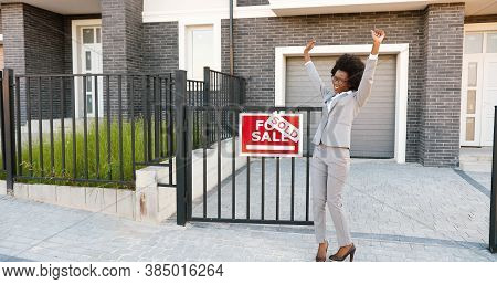 Happy Young African American Beautiful Female Real-estate Agent Dancing And Having Fun At Suburb Str