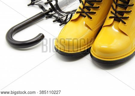 Yellow Rubber Boots Close-up. A Pair Of Women's Rain Boots Next To A Transparent Umbrella-cane On A 