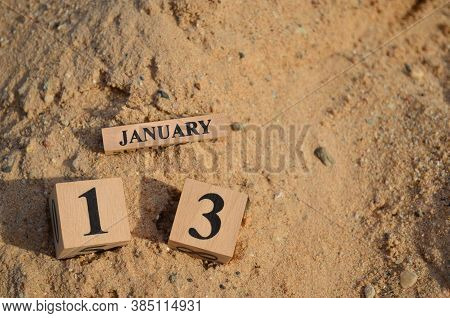 January 13, Number Cube With A Sand Background.