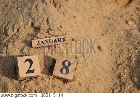 January 28, Number Cube With A Sand Background.