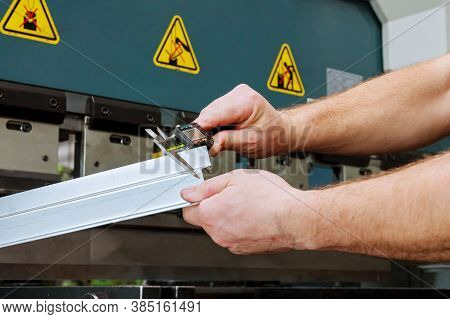 The Worker Measures The Product After Bending On A Hydraulic Press For Bending Sheet Metal.