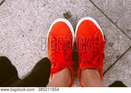 Female Feet Seen From Above. Selfie For Any Use. Foot And Legs In Red Sneakers. Foot Standing On The