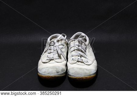 Used Sneakers Shoes In White Color But It Grimy And Gloomy Color, Put Pair On Black Floor. It Is A S
