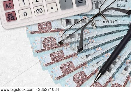 5 Egyptian Pounds Bills Fan And Calculator With Glasses And Pen. Business Loan Or Tax Payment Season