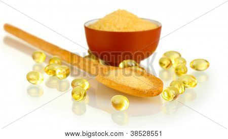 Gelatin in a bowl and wooden spoon on white background close-up