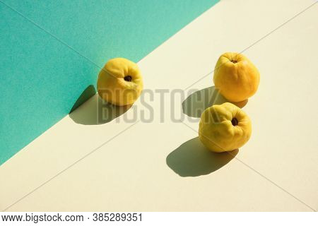 Autumn Ripe Yellow Quince Fruits On Mint Green And Yellow Layered Paper. Minimal Style, Fall Backgro