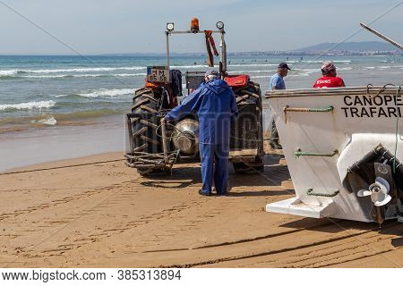 Costa Da Caparica, Portugal - September 10, 2020: An Artel Of Fishermen Trawls Fish From The Tourist
