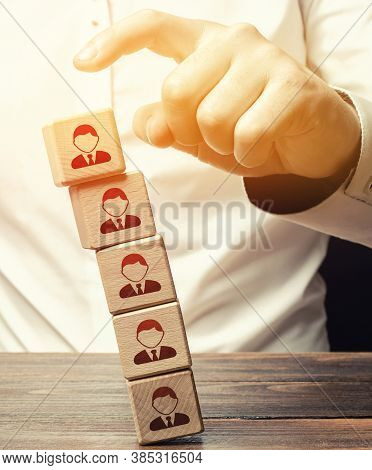Man Knocks Down A Tower Of Blocks With Employees. Mass Layoffs, Closing A Business Company. Dismissa