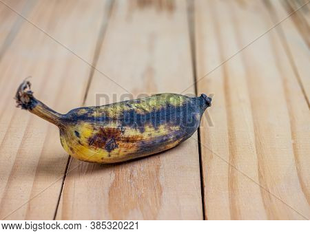 Rootten Banana On Wooden Texture Blurred Background
