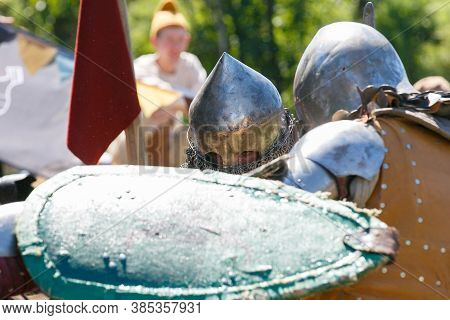 Knight Tournament. Medieval Restorers Fight With Swords In Armor At A Knightly Tournament