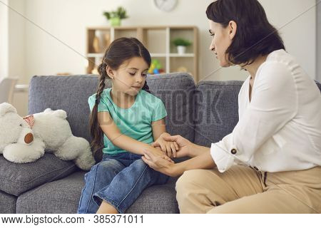 Mother Sitting With Daughter, Holding Her Hands, Talking To Her And Teaching Her Something