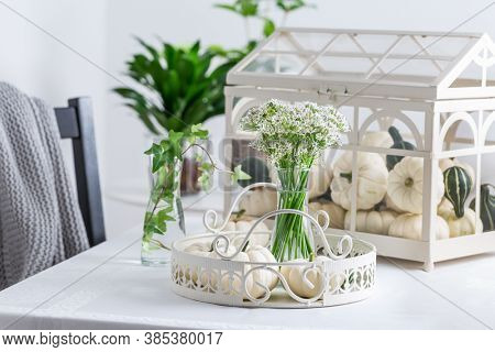 Thanksgiving table decoration with white pumpkins and sweet garlic flowers (Tulbaghia violacea)
