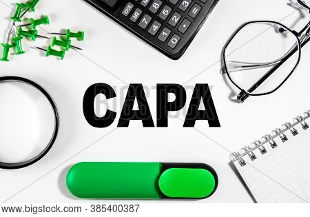 Business Concept. On The White Table Is A Calculator, Magnifer, Green Markers, Glasses, Pins And A N