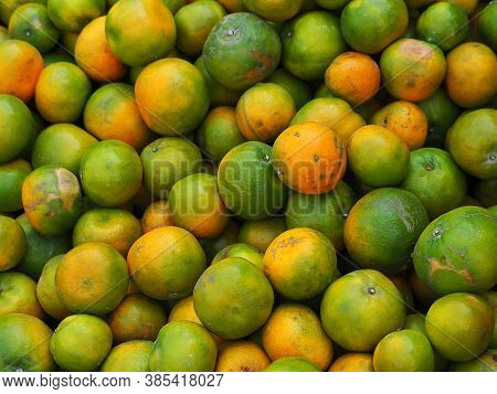Pile Of Tangerines For Sale In The Market. Full Frame Photo. Concept Of Fruits Healthy