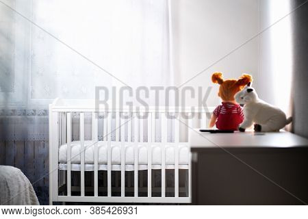 Childrens Room With An Empty Cradle And Toys On The Dresser. Copy Space. The Concept Of Abortion And
